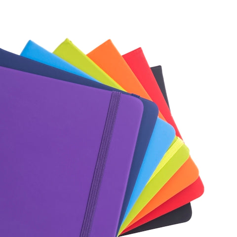 A bunch of different colored notebooks stacked on top of each other