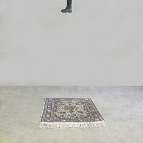 A foot descends towards a rug.