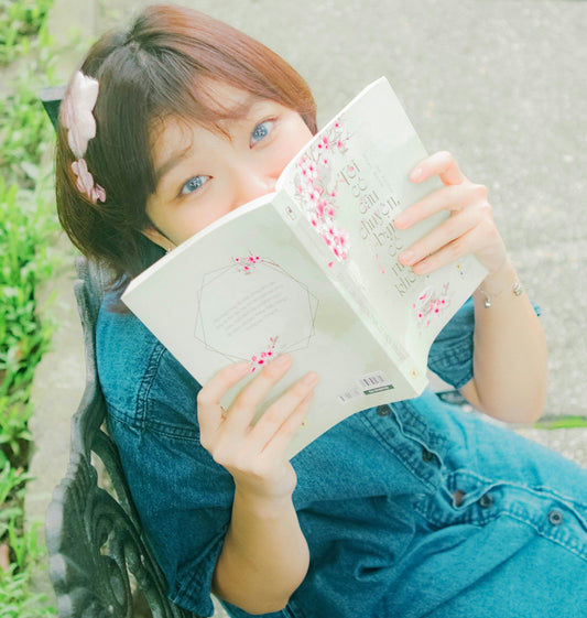 a woman sitting on a bench reading a book